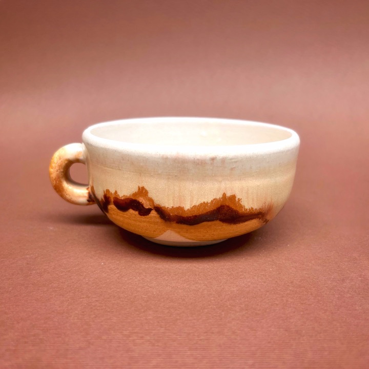 Taza cerámica de Napoleón Retana con esmalte transparente y esmalte shino falso aplicado.